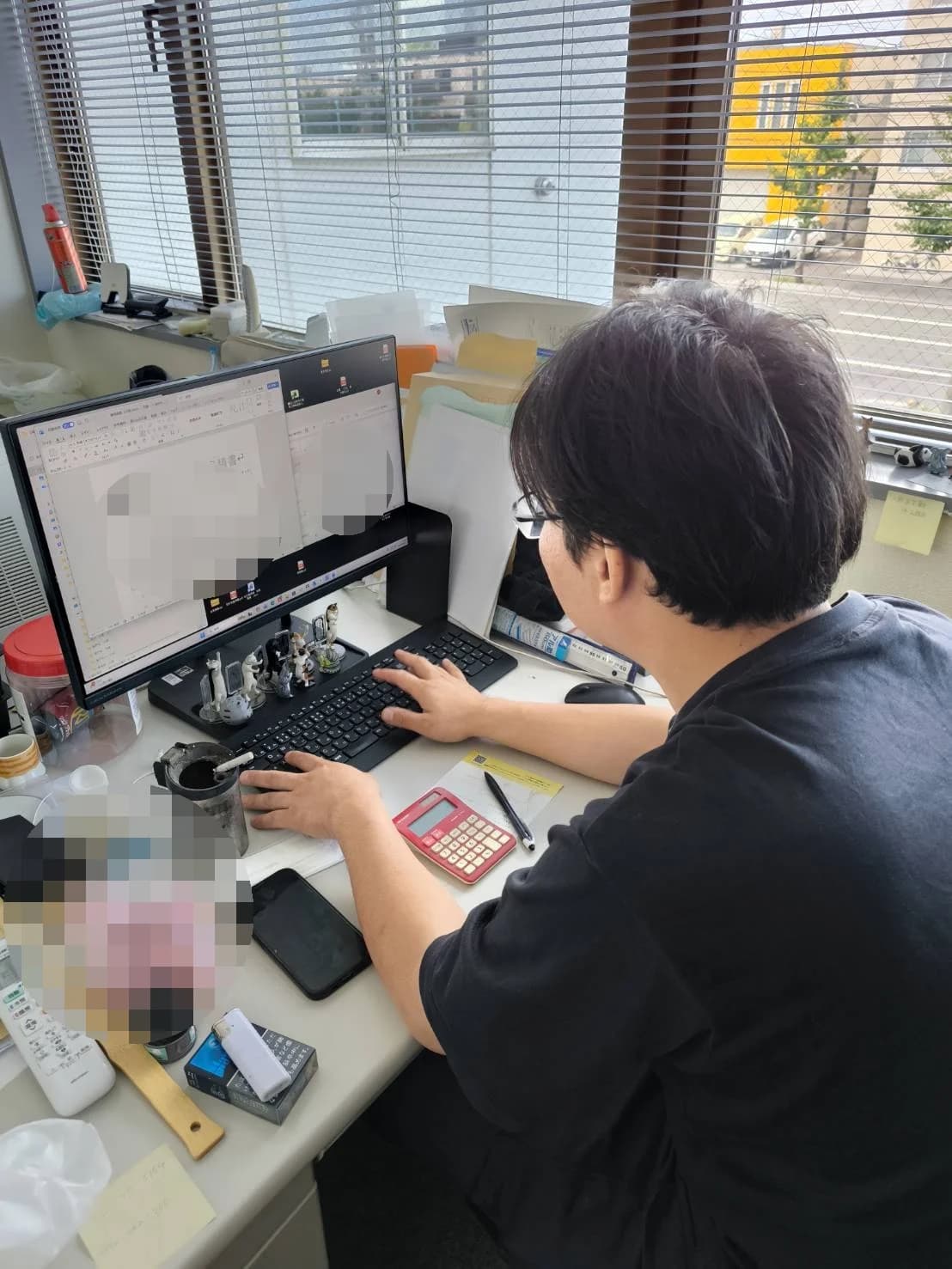 事務所のパソコンで業務にあたる丸山健太